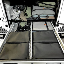 Load image into Gallery viewer, Storage compartments with organized gear inside a vehicle