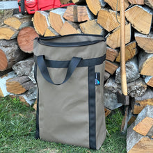 Load image into Gallery viewer, Firewood bag next to a stack of firewood.