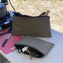 Load image into Gallery viewer, Two grey pouches on a table with camping gear including a cutlery