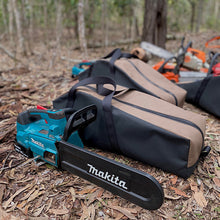 Load image into Gallery viewer, Makita chainsaw with a carrying case on a forest floor