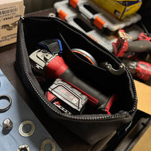 Load image into Gallery viewer, Black tool pouch with angle grinder and battery on a workshop bench.