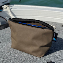 Load image into Gallery viewer, Brown canvas bag with a black zipper on a boat deck