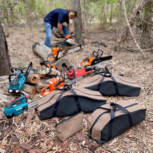Load image into Gallery viewer, Chainsaws and carrying cases on the ground in a forest setting