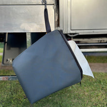 Load image into Gallery viewer, Grey paper towel bag with a black zipper hanging on a camper outdoors.