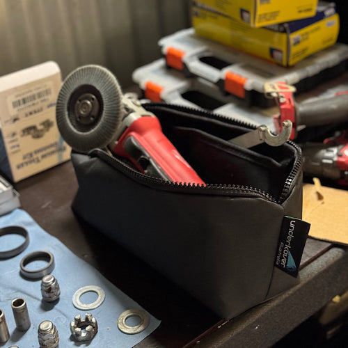 Black tool pouch with tools on a workbench, featuring Underkover brand.