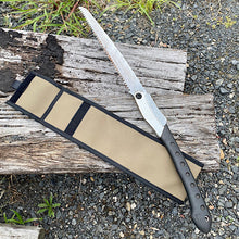 Load image into Gallery viewer, Folding saw with a sheath on a wooden log and gravel background