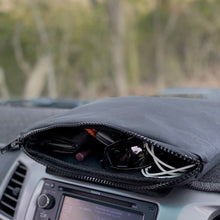 Load image into Gallery viewer, Car dashboard with a zippered pouch containing sunglasses, wallet, and other items, blurred natural background