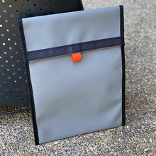 Load image into Gallery viewer, Gray pouch with a black strap and orange tag on a textured surface