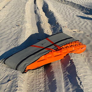 Recovery tracks and canvas bag on sand