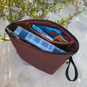 Tackle bag on sand full of lures and tackle