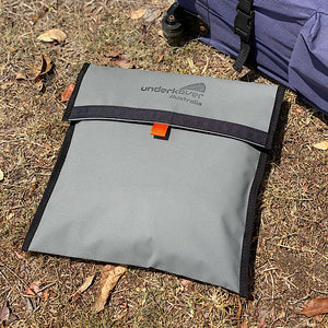 closed canvas bag on grass next to gazebo